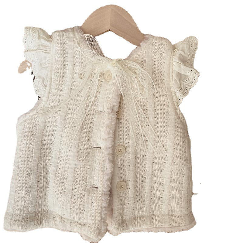 comme deux enfants Deze mouwloze crèmekleurige overgooier is perfect voor kindjes vanaf 1 jaar. Het heeft een warm teddy achterpand en een knoopsluiting. Het is niet alleen functioneel, maar ook super schattig!