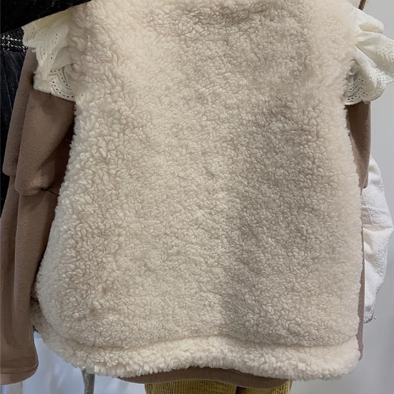 comme deux enfants Deze mouwloze crèmekleurige overgooier is perfect voor kindjes vanaf 1 jaar. Het heeft een warm teddy achterpand en een knoopsluiting. Het is niet alleen functioneel, maar ook super schattig! achterkant.