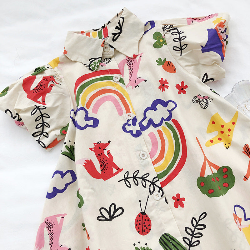 Jip zomerjurk met all-over print| comme deux Enfants | Ontdek de charme van onze Jip zomerjurk, vervaardigd uit luchtig katoen en voorzien van een speels opstaand kraagje. Deze jurk is niet alleen een genot om te dragen dankzij de comfortabele knoopsluiting aan de voorzijde, maar ook een lust voor het oog door de korte pofmouwtjes die een speelse touch geven.